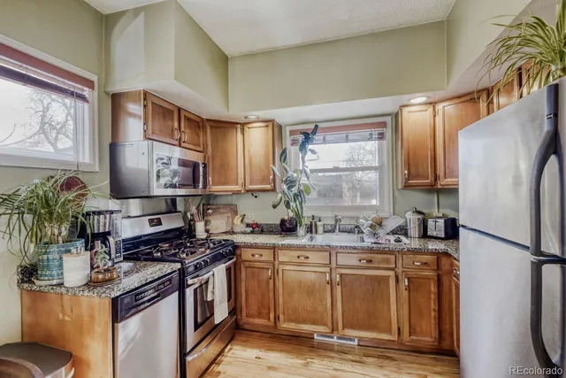 a kitchen with stainless steel appliances granite countertop a stove a sink and a refrigerator