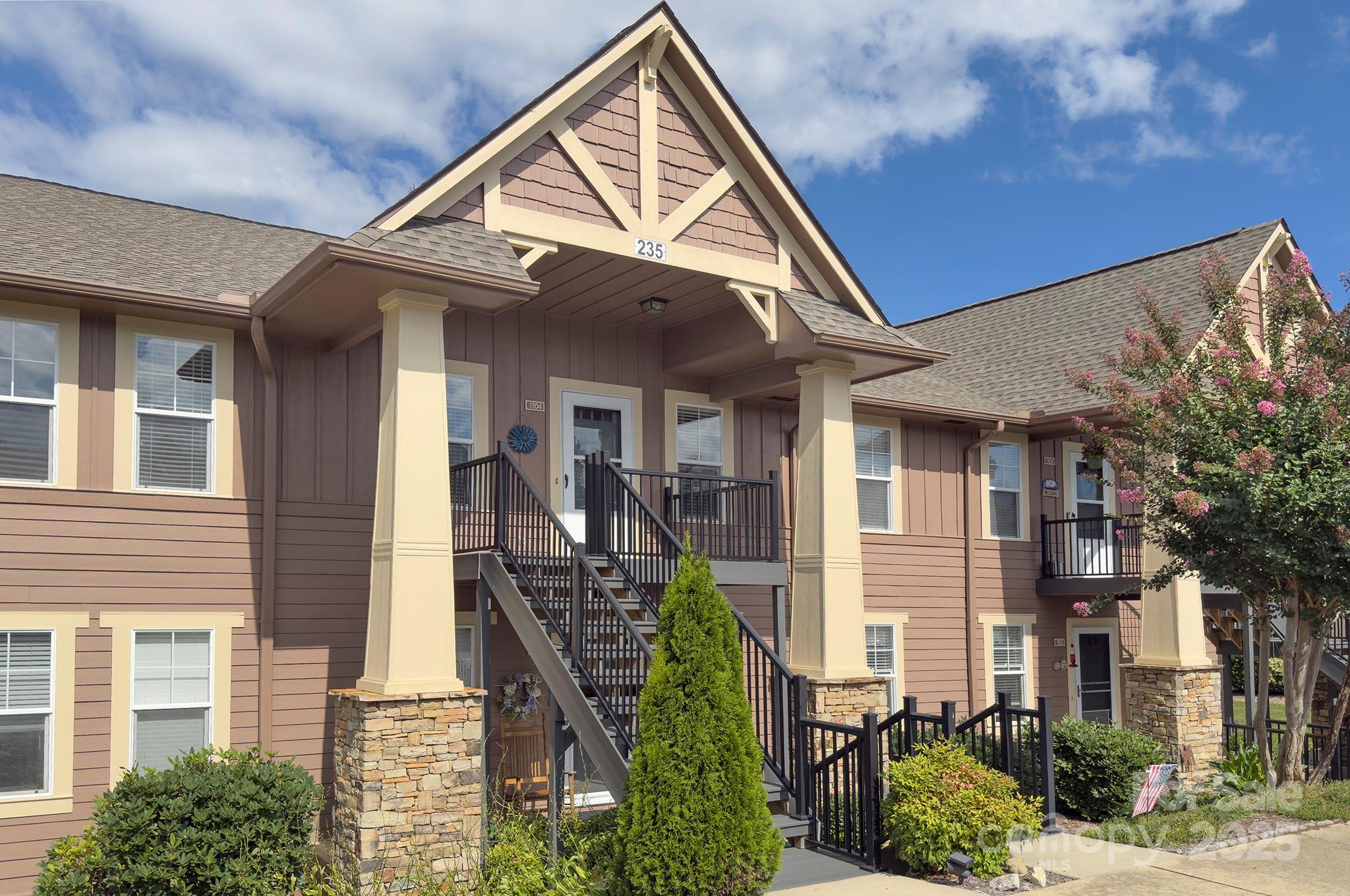 a view of a house with many windows and plants