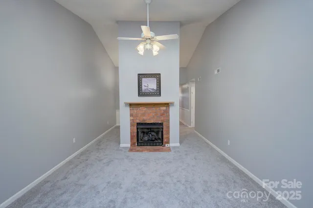 an empty room with fireplace and fan