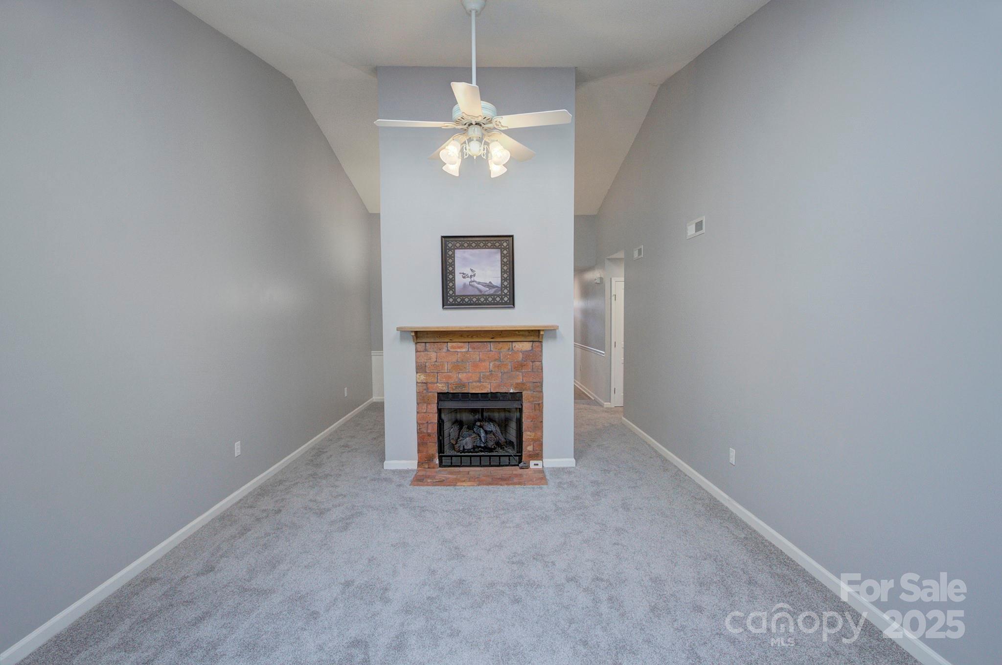 1104 Deermouse Way Hendersonville, NC 28792 - Photo 11 of 32 an empty room with fireplace and fan