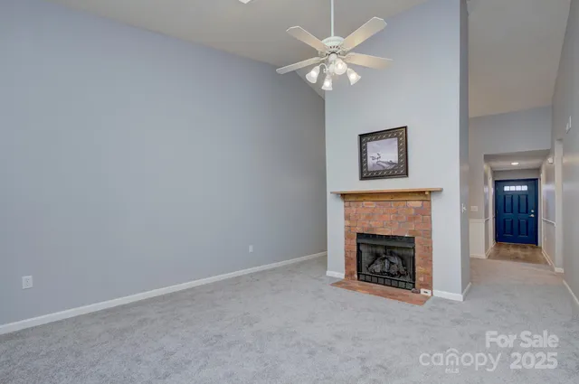 an empty room with fireplace and fan