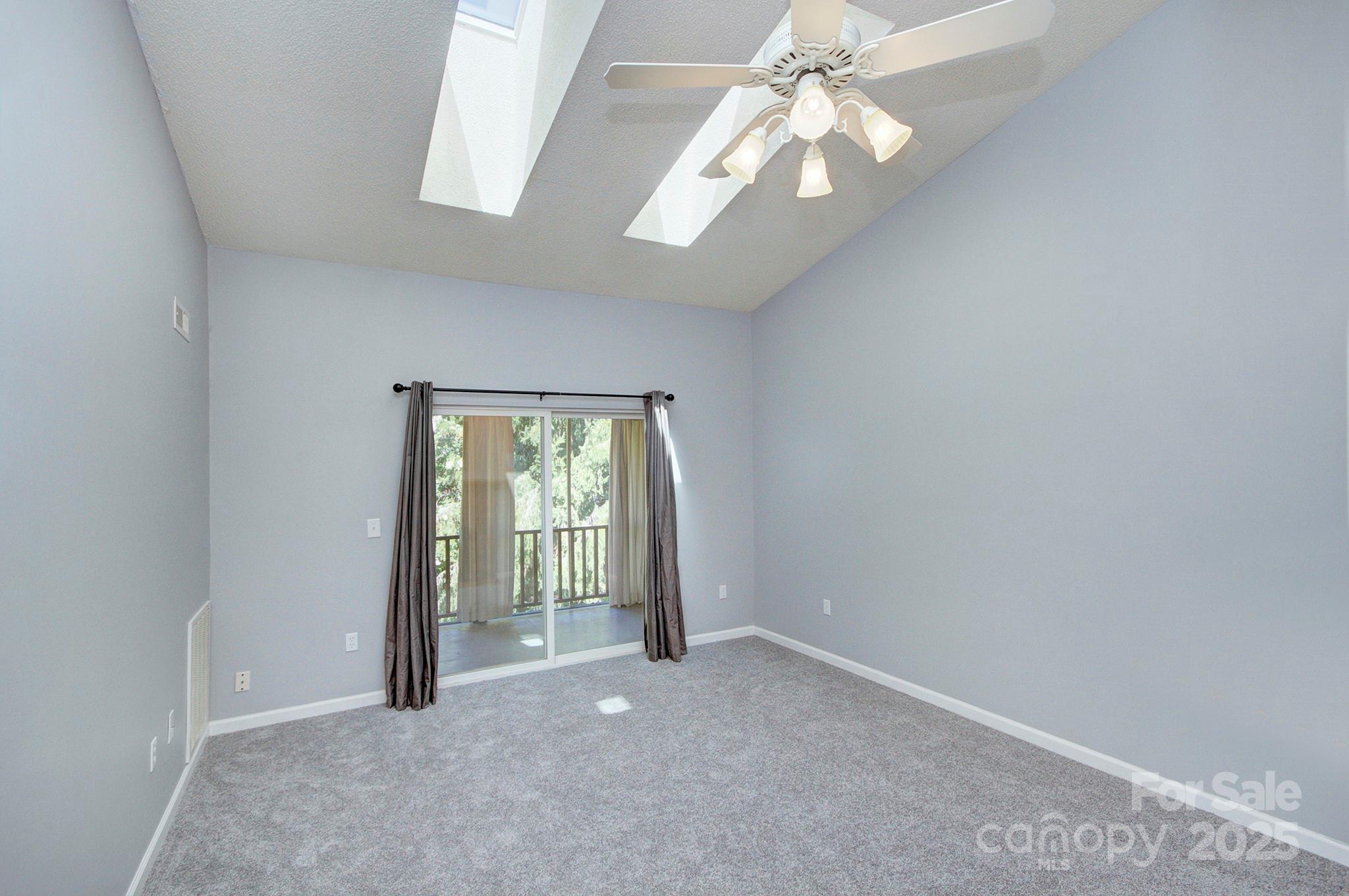 1104 Deermouse Way Hendersonville, NC 28792 - Photo 13 of 32 an empty room with a chandelier fan and windows