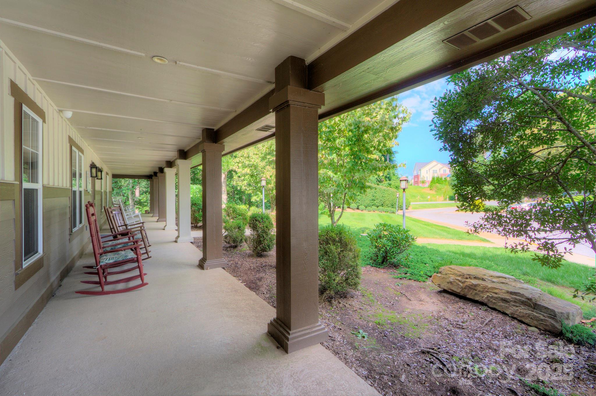 1104 Deermouse Way Hendersonville, NC 28792 - Photo 25 of 32 a view of a patio with table and chairs plants and large trees
