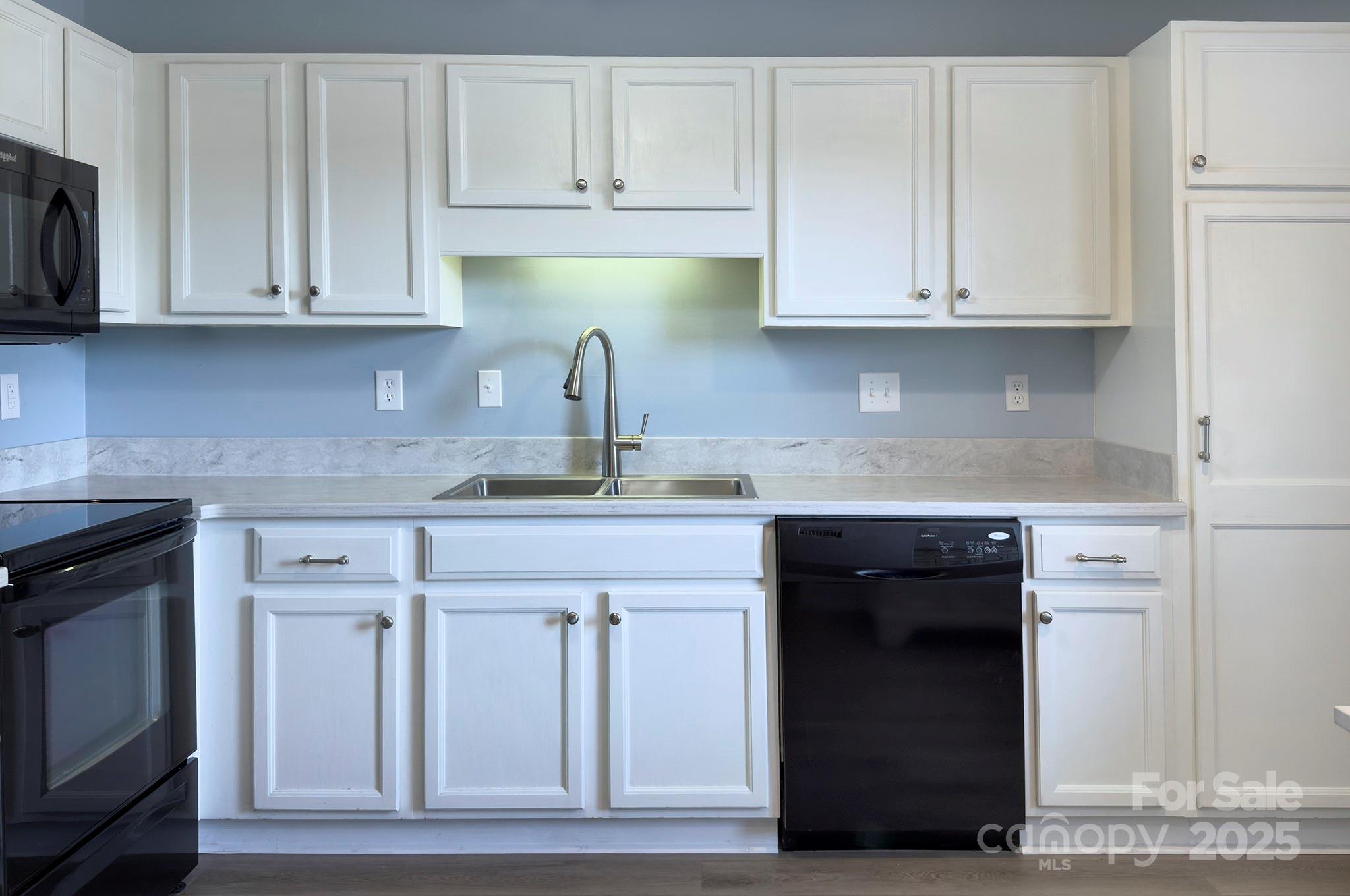 1104 Deermouse Way Hendersonville, NC 28792 - Photo 5 of 32 a kitchen with granite countertop white cabinets and stainless steel appliances