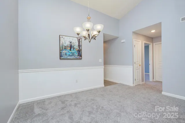 an empty room with a chandelier fan
