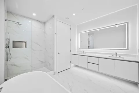 a spacious bathroom with a bathtub sink and mirror