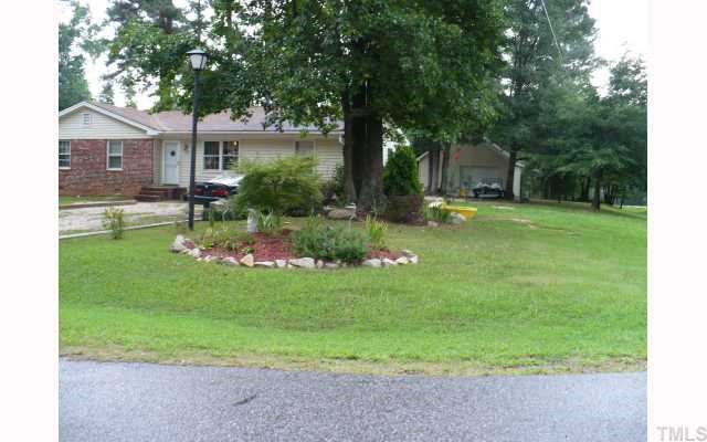 a view of a house with a backyard and a tree