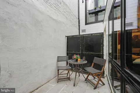 a patio with table and chairs and potted plants