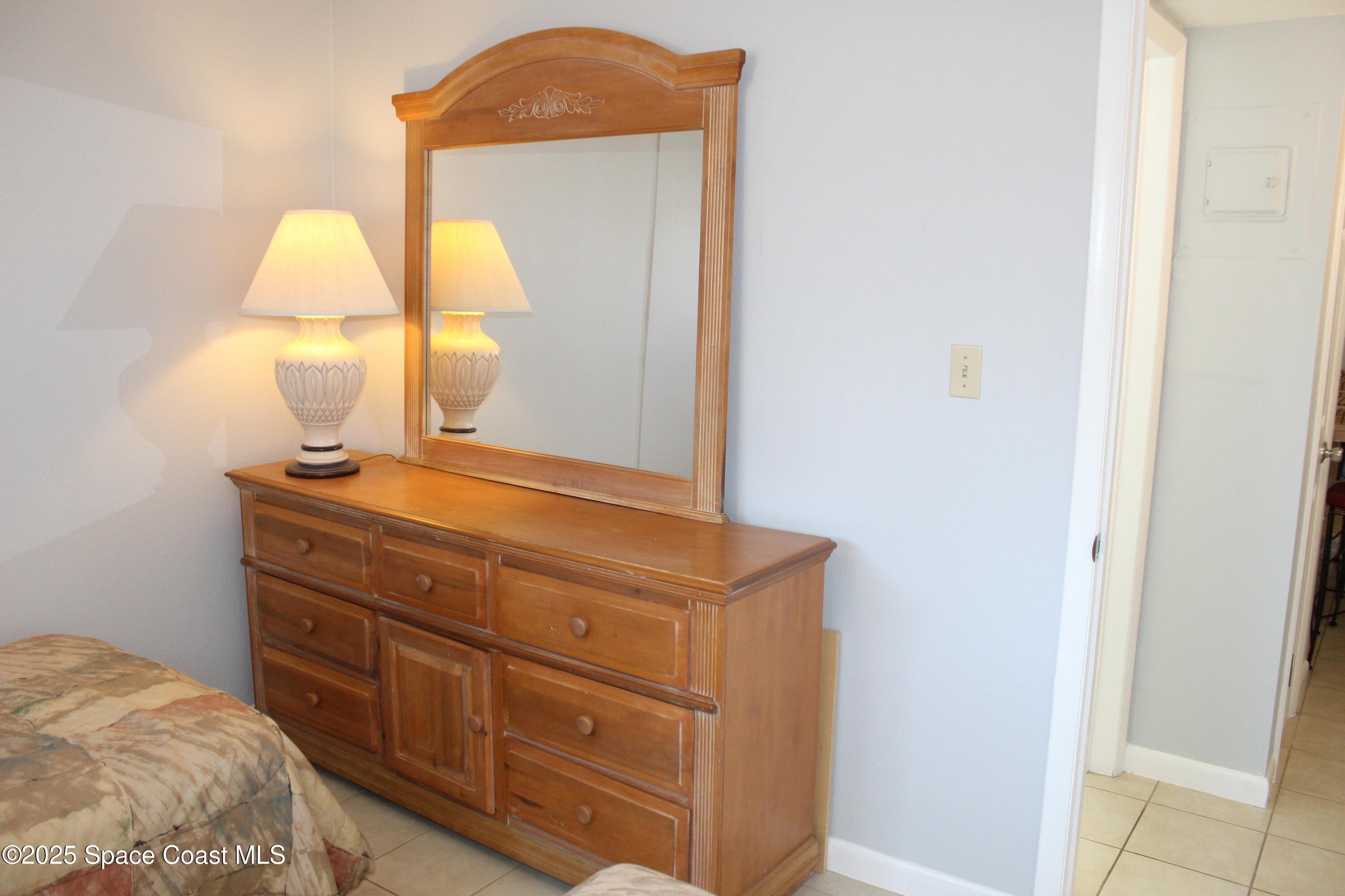 3150 North Atlantic Avenue, Unit 14880 Cocoa Beach, FL 32931 - Photo 11 of 13 a bedroom with a bed and a mirror