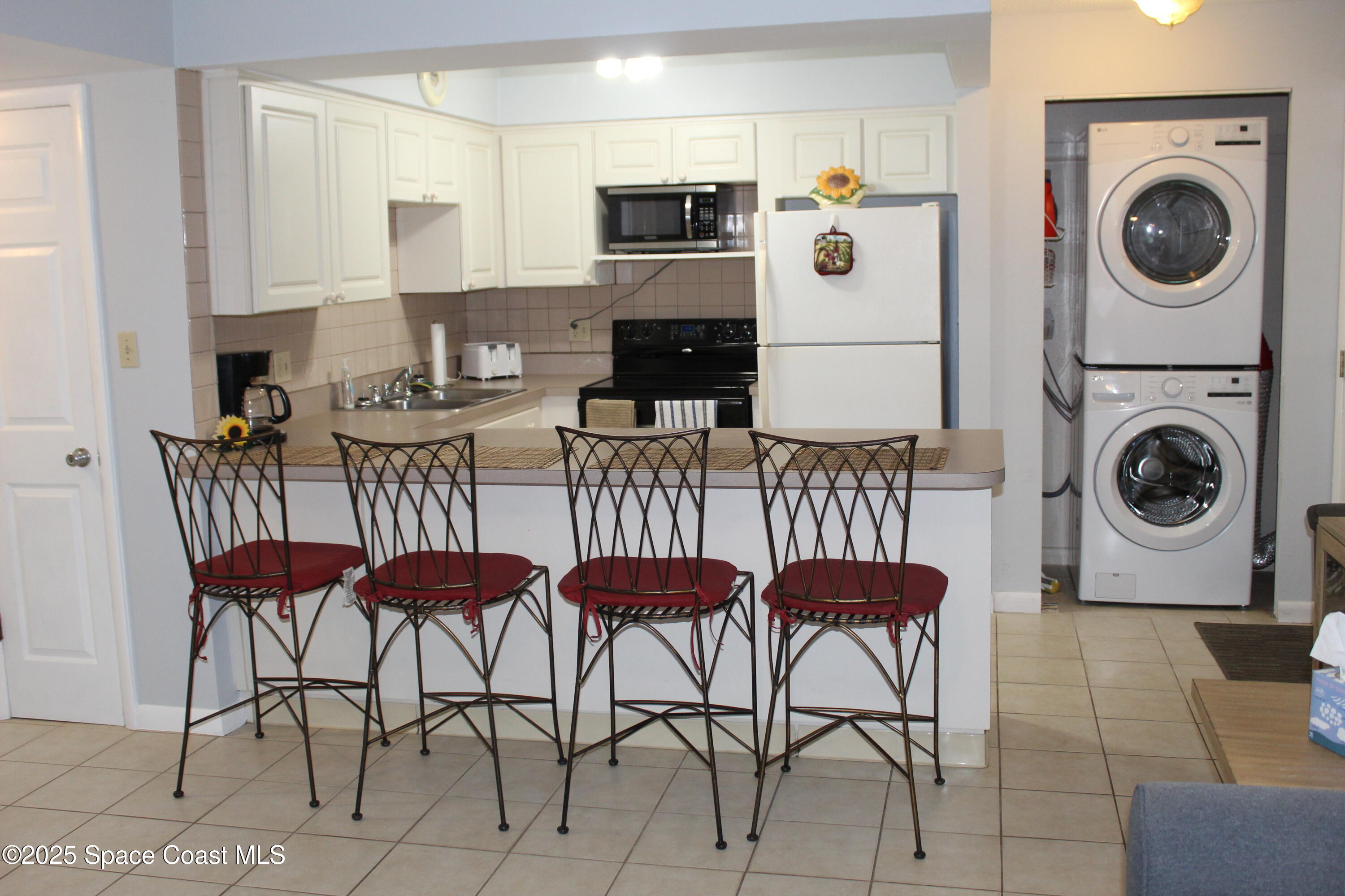 3150 North Atlantic Avenue, Unit 14880 Cocoa Beach, FL 32931 - Photo 13 of 13 a view of kitchen and dining area with furniture