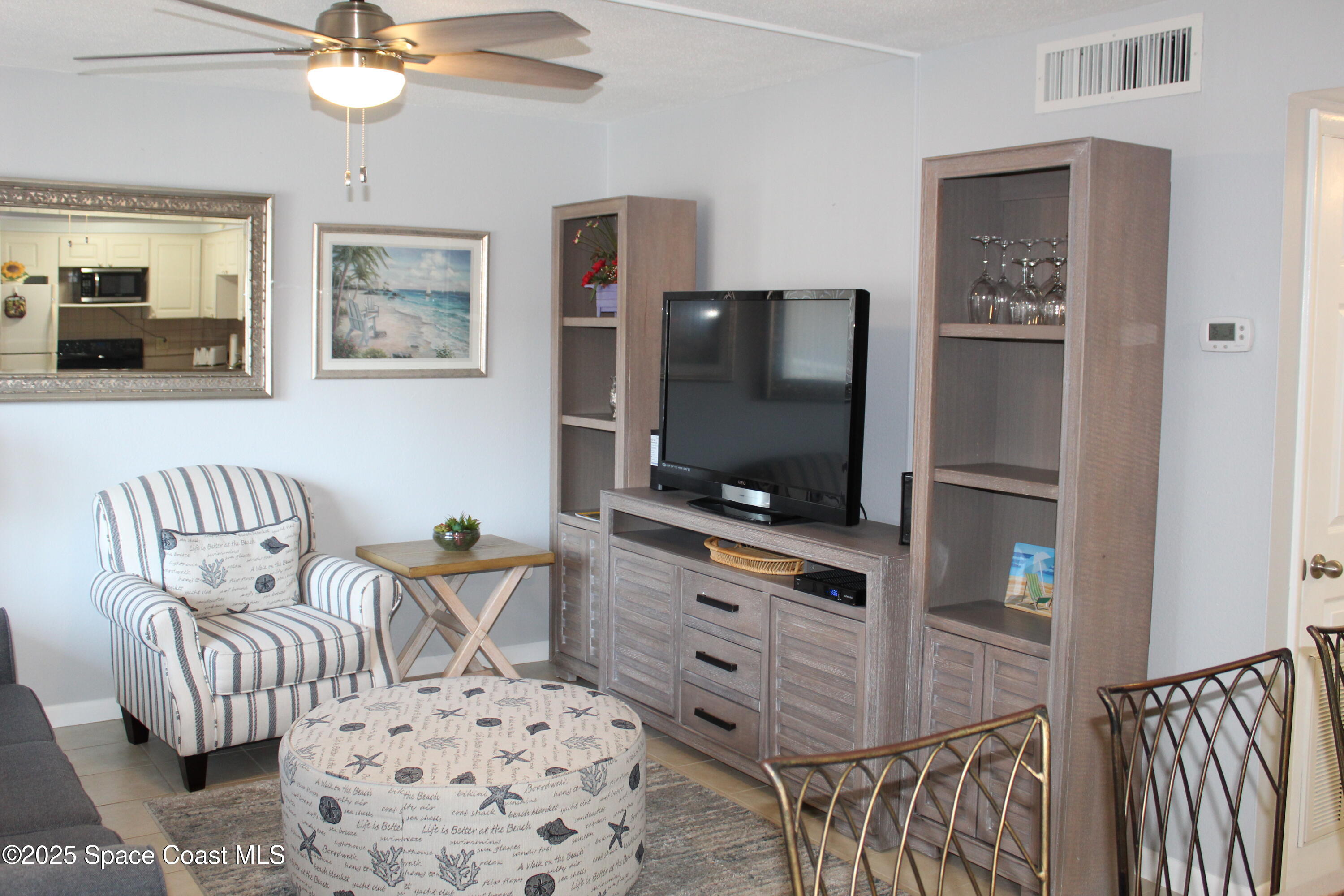 3150 North Atlantic Avenue, Unit 14880 Cocoa Beach, FL 32931 - Photo 4 of 13 a living room with furniture and a flat screen tv