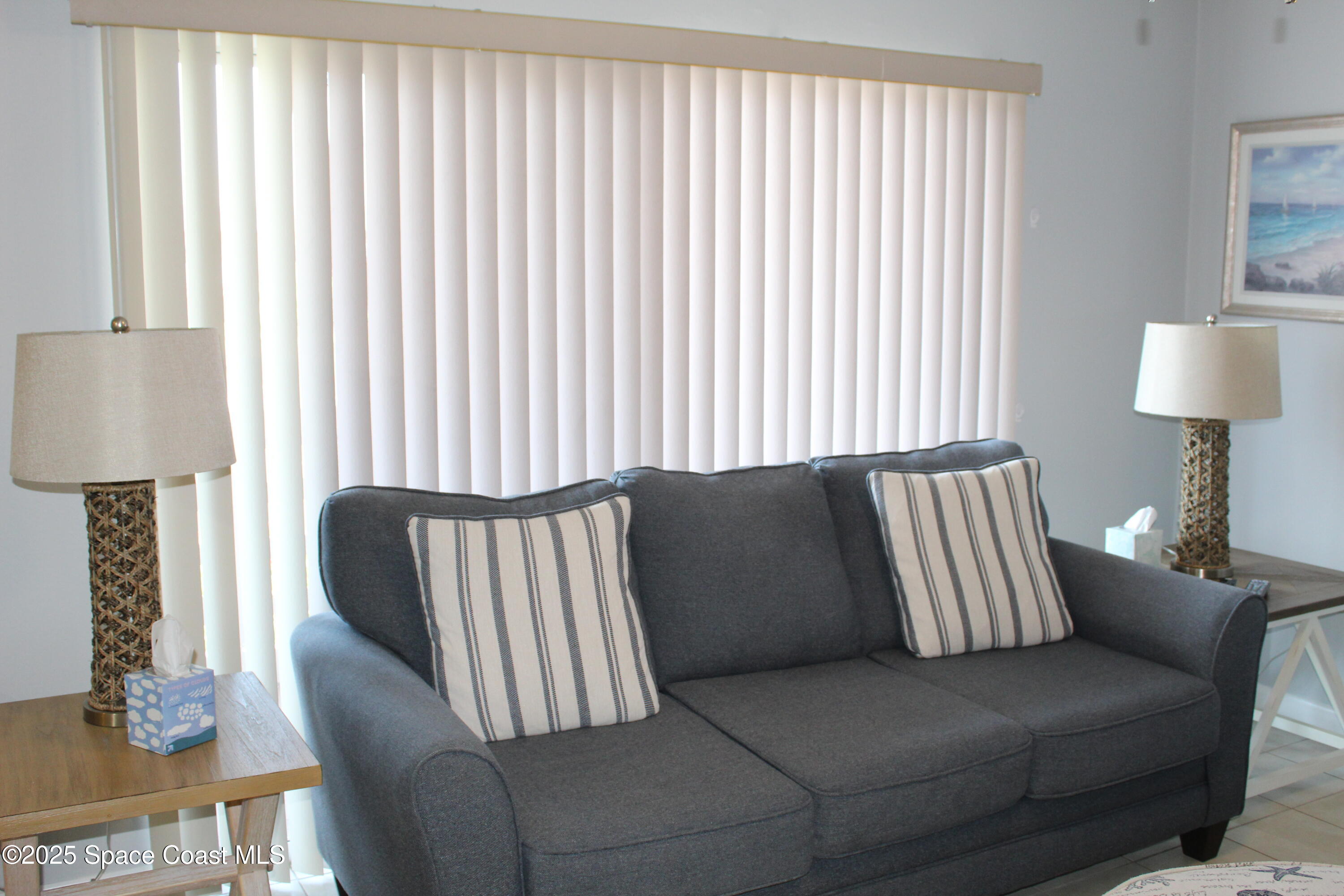 3150 North Atlantic Avenue, Unit 14880 Cocoa Beach, FL 32931 - Photo 6 of 13 a living room with furniture and a lamp