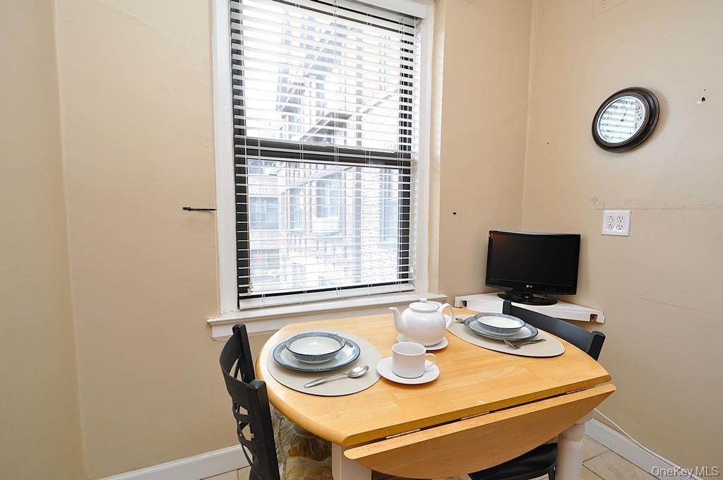 143 Garth Road, Unit 5J Scarsdale, NY 10583 - Photo 29 of 47 a view of a dining room with furniture and a window