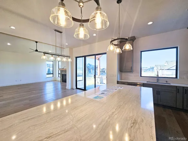 a large kitchen with stainless steel appliances granite countertop a lot of counter space and wooden floor