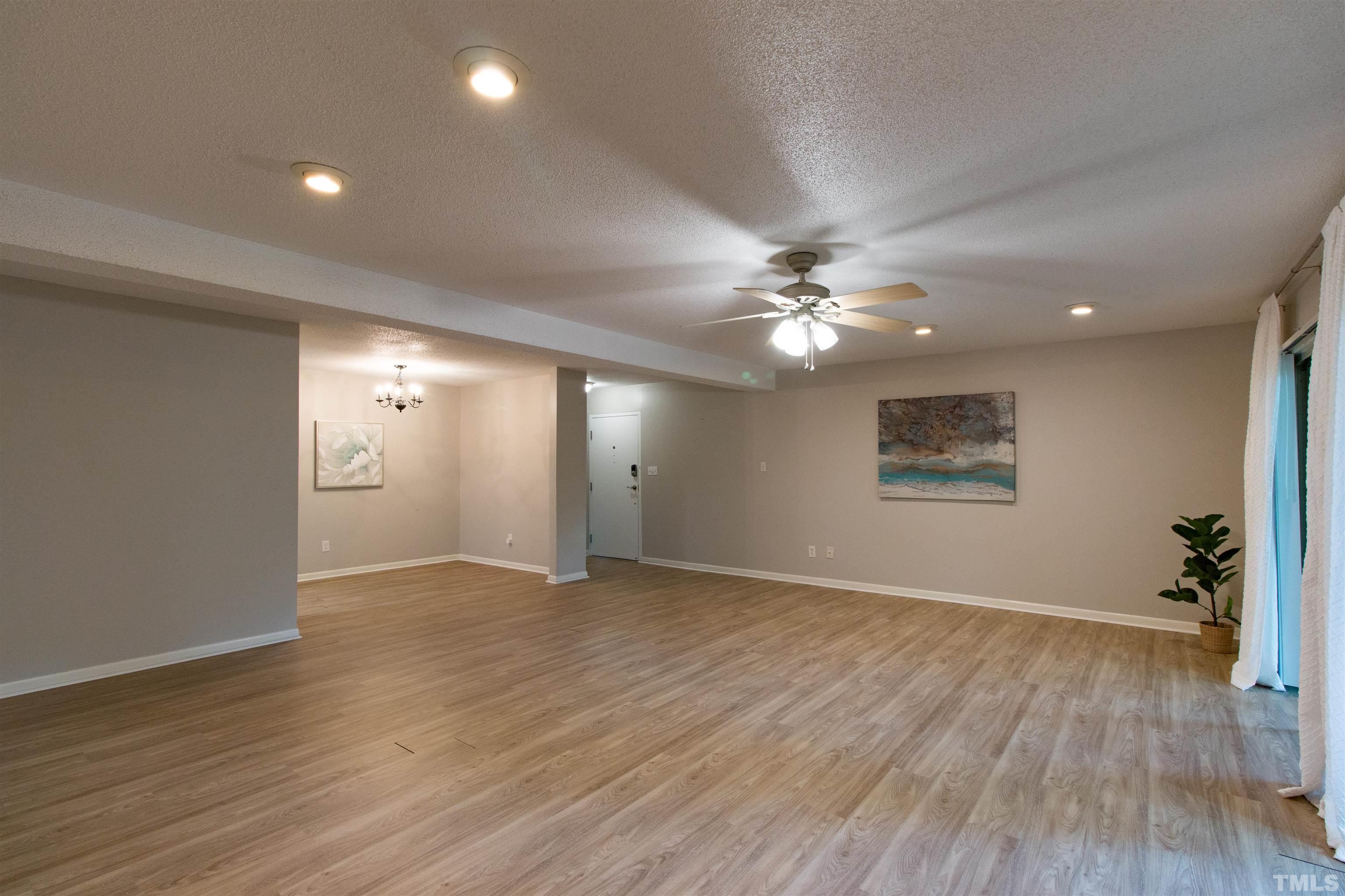 4711 Edwards Mill Road, Unit C Raleigh, NC 27612 - Photo 2 of 13 an empty room with wooden floor and windows