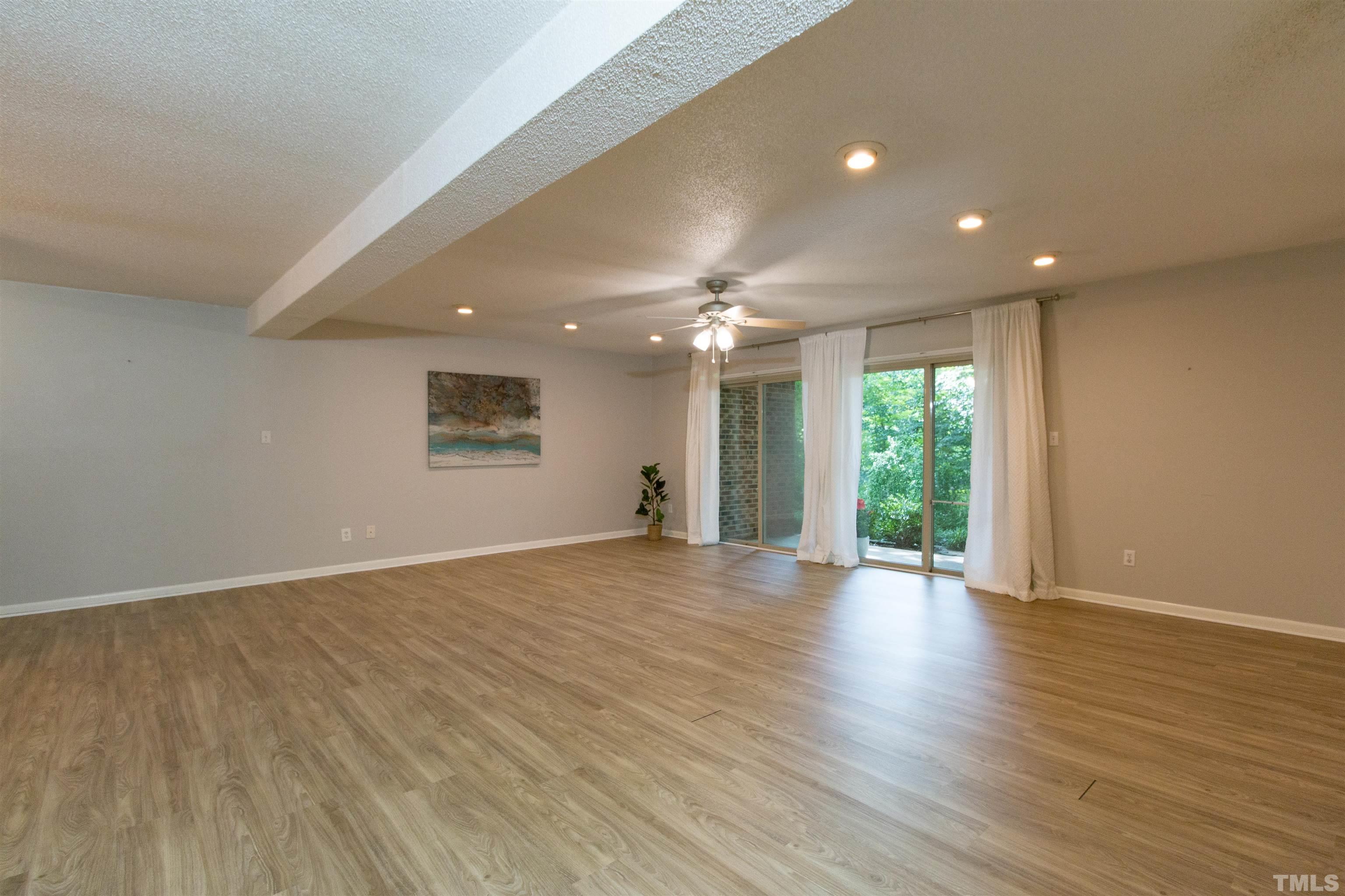 4711 Edwards Mill Road, Unit C Raleigh, NC 27612 - Photo 3 of 13 a view of an empty room with wooden floor and a window