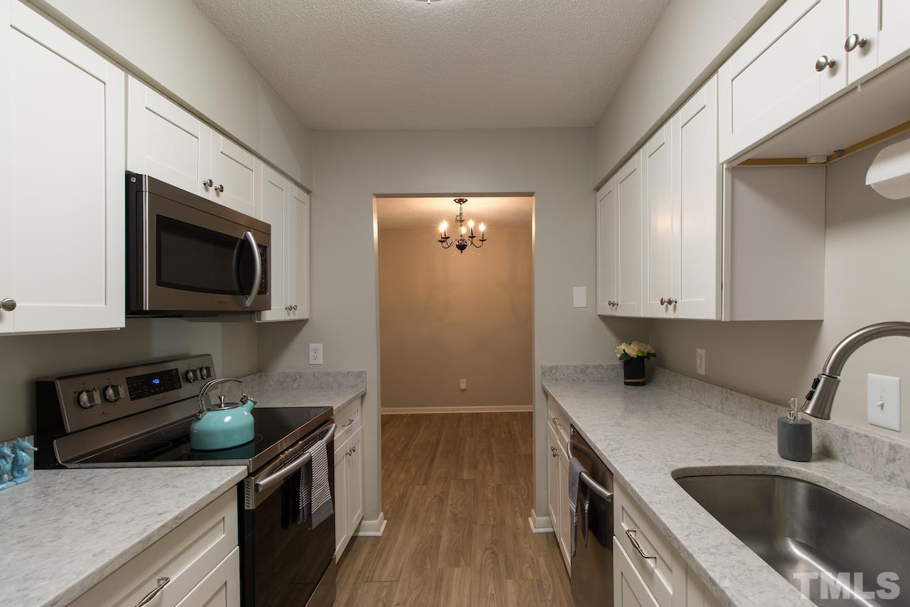 4711 Edwards Mill Road, Unit C Raleigh, NC 27612 - Photo 5 of 13 a kitchen with stainless steel appliances granite countertop a sink a stove and a microwave