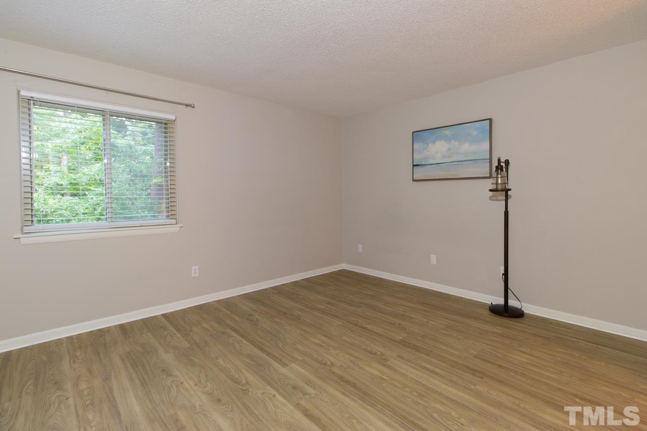 4711 Edwards Mill Road, Unit C Raleigh, NC 27612 - Photo 6 of 13 a view of an empty room with wooden floor and a window