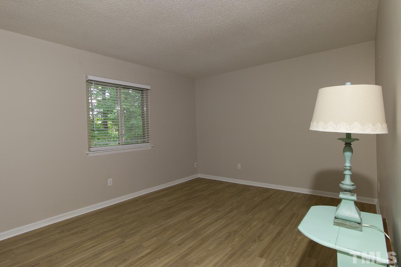 4711 Edwards Mill Road, Unit C Raleigh, NC 27612 - Photo 8 of 13 a room with wooden floor a mirror and a table