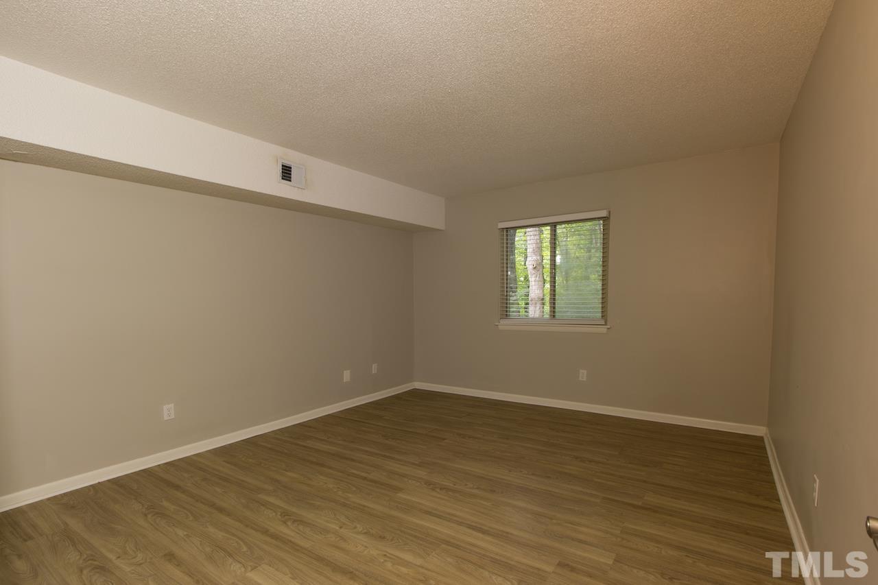 4711 Edwards Mill Road, Unit C Raleigh, NC 27612 - Photo 9 of 13 wooden floor in an empty room with a window