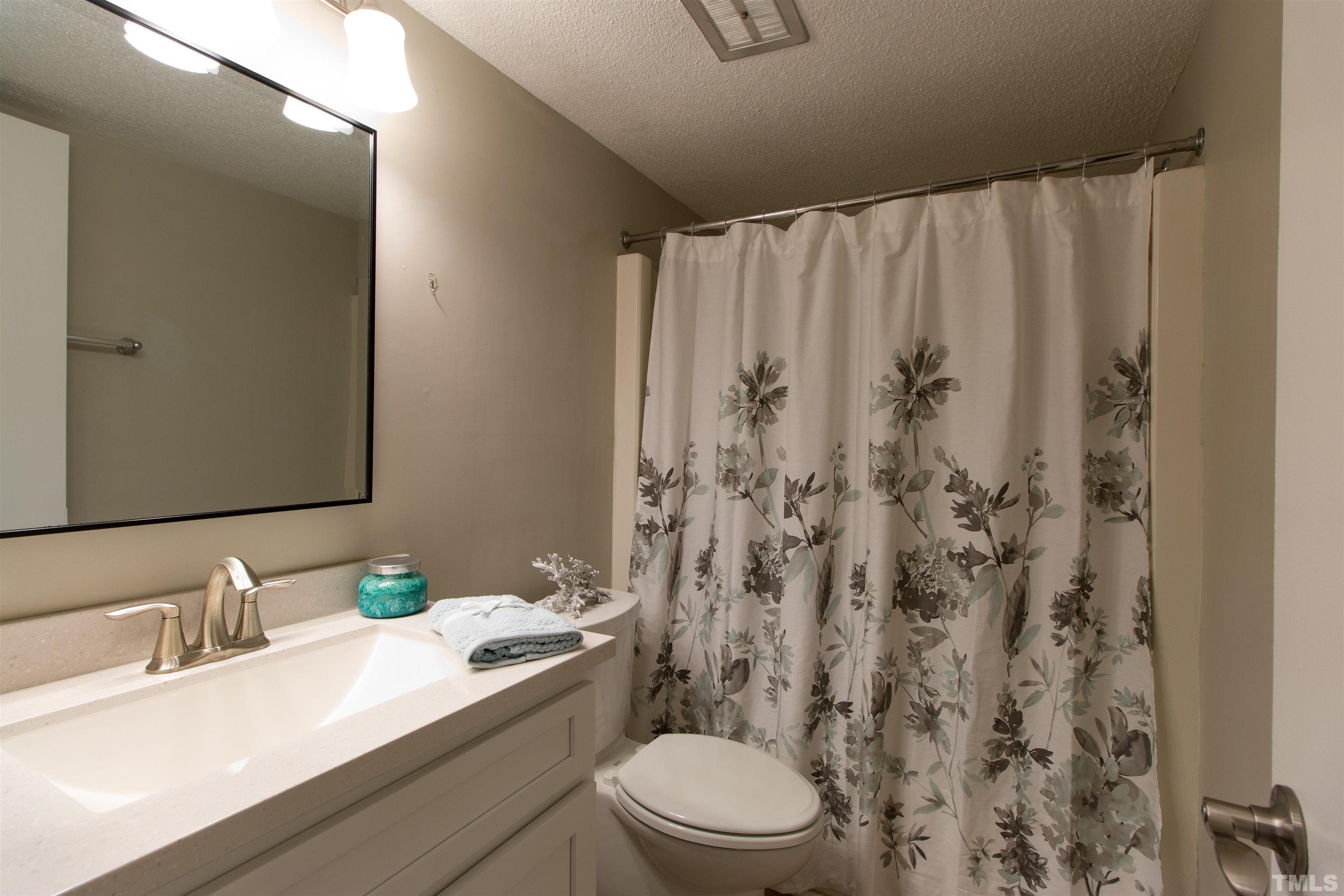 4711 Edwards Mill Road, Unit C Raleigh, NC 27612 - Photo 10 of 13 a bathroom with a granite countertop sink a toilet and a mirror