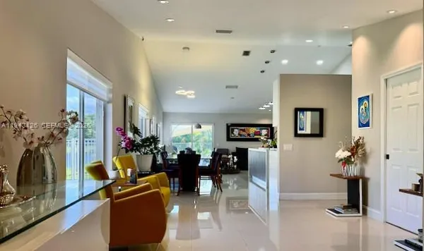a view of kitchen with kitchen island stainless steel appliances refrigerator stove dining table and chairs