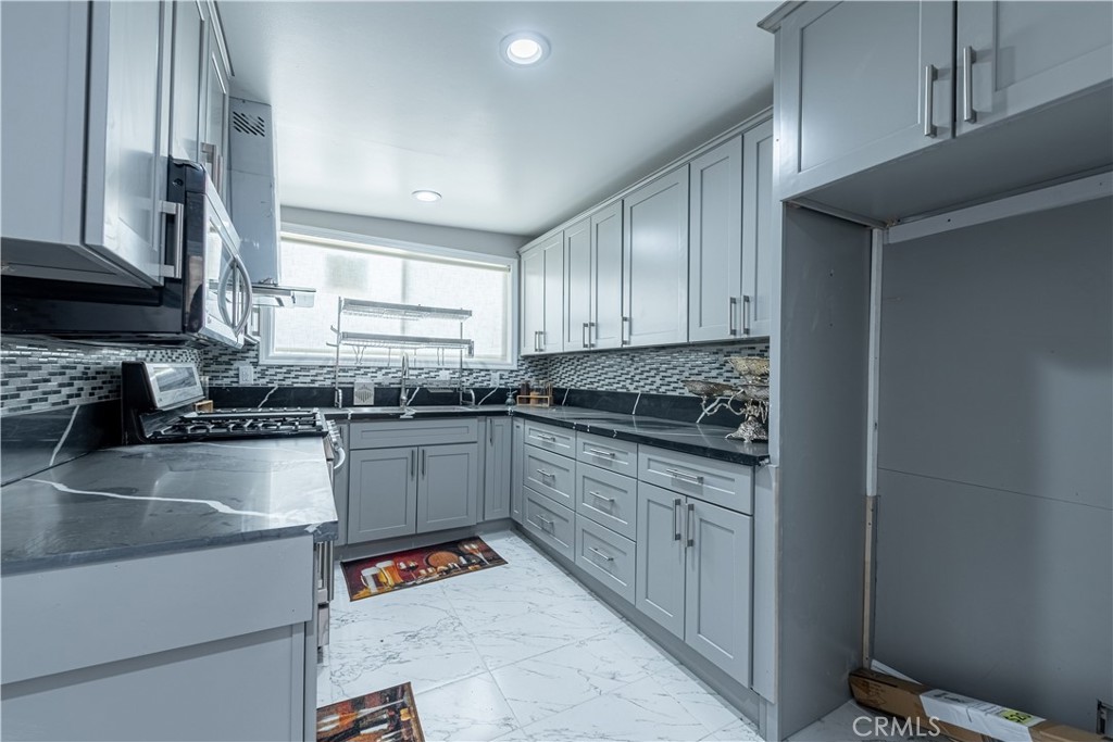 4759 Cochran Street Simi Valley, CA 93063 - Photo 25 of 71 a kitchen with granite countertop stainless steel appliances a sink and cabinets