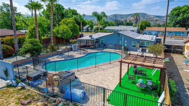 an aerial view of a swimming pool with a yard