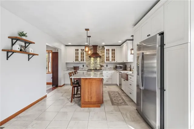 a kitchen with stainless steel appliances granite countertop a refrigerator and a sink