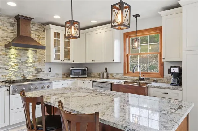 a kitchen with stainless steel appliances granite countertop a sink stove and refrigerator