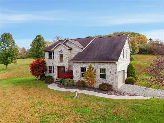 a front view of house with yard and green space