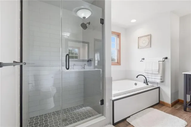 a bathroom with a bathtub a shower a sink and mirror