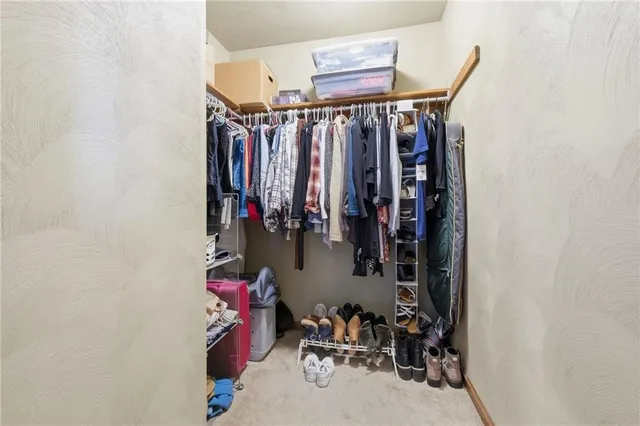 a view of walk in closet with clothes and shoes
