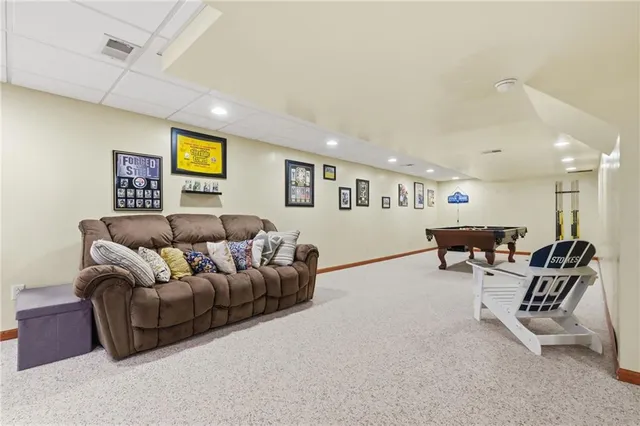 a living room with furniture and a wall painting