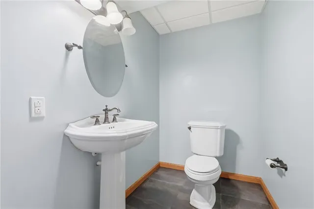 a bathroom with a sink a toilet and a mirror