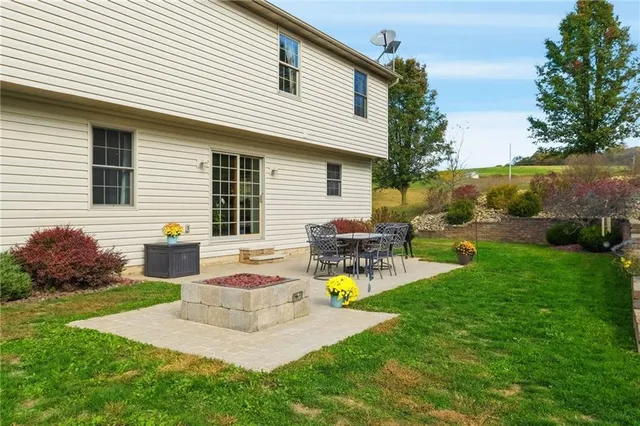 a view of a house with backyard and sitting area