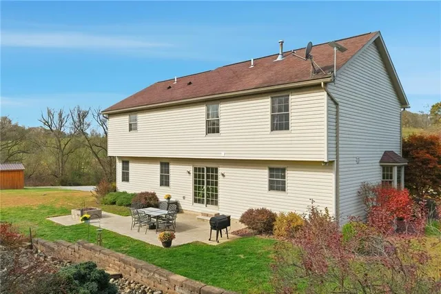 a backyard of a house with table and chairs