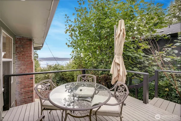 a balcony with wooden floor table and chairs
