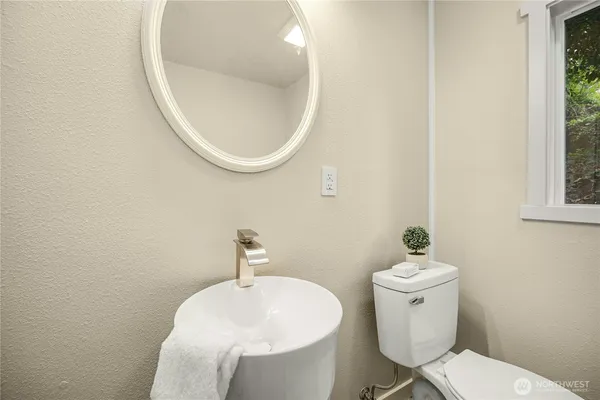 a bathroom with a sink mirror and toilet