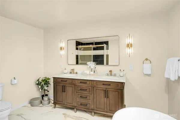 a bathroom with a granite countertop sink mirror and toilet