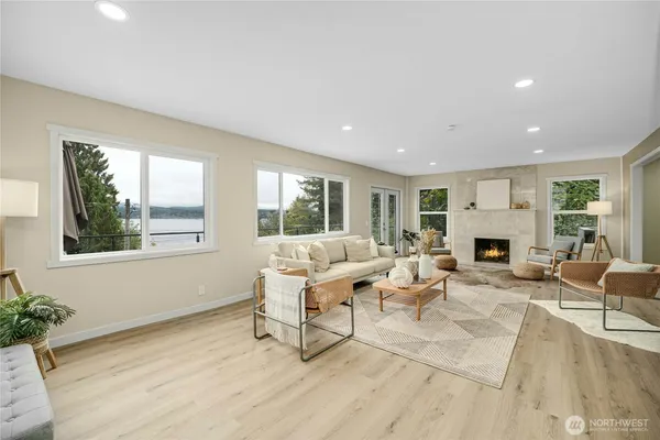 a living room with furniture a fireplace and a large window