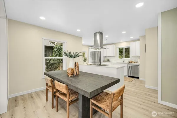a kitchen with a table chairs sink and cabinets