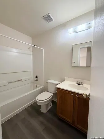 a bathroom with a sink toilet vanity and tub