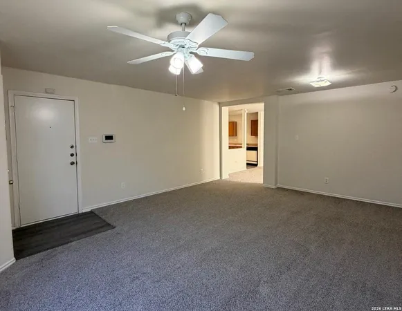 an empty room with chandelier fan
