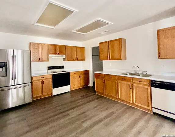 a large kitchen with stainless steel appliances granite countertop a stove a sink dishwasher and a refrigerator