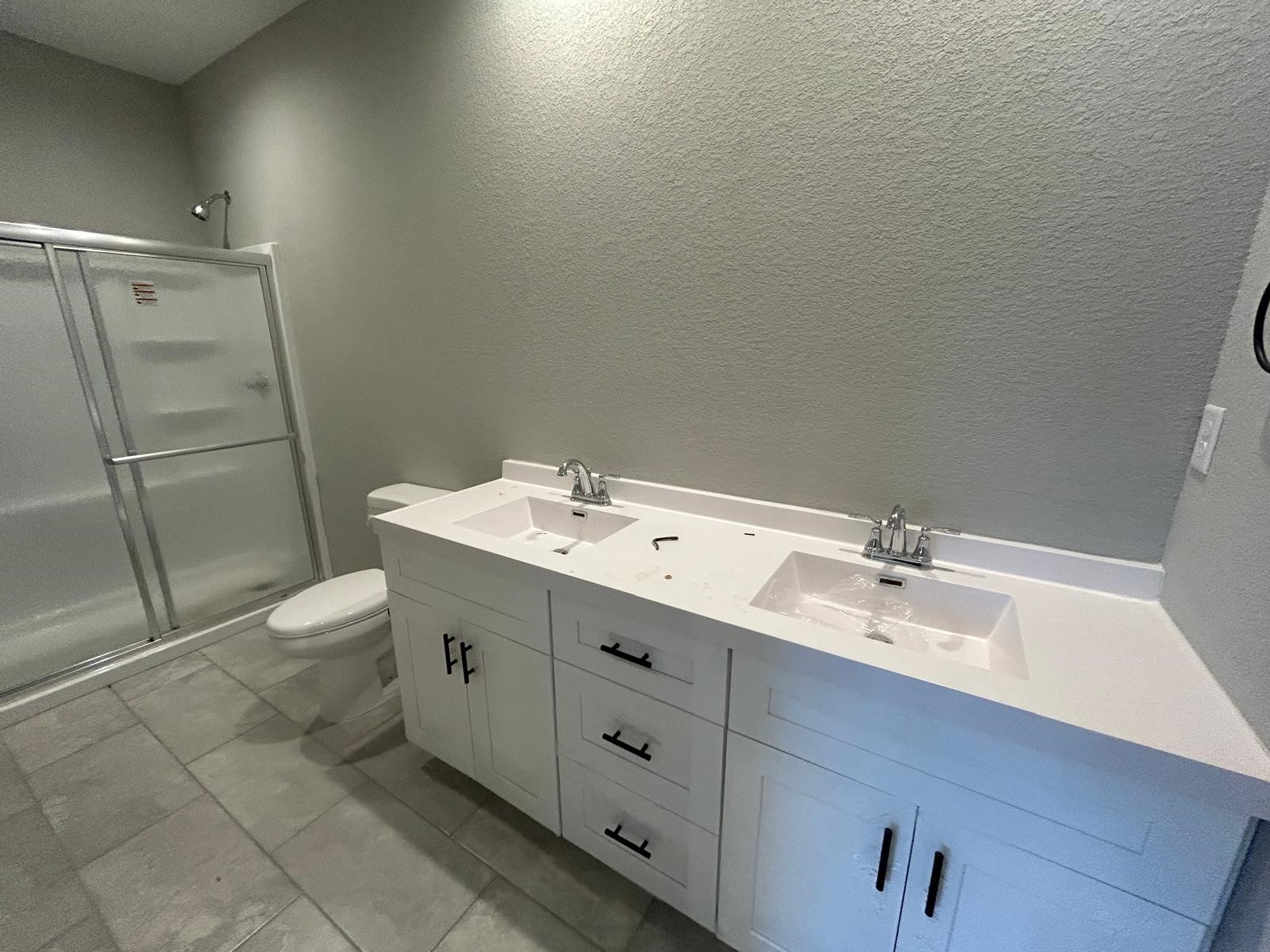 14010 Longstreet Road, Unit 14 Willis, TX 77318 - Photo 14 of 18 a bathroom with a double vanity sink toilet and shower