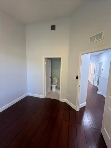 a view of a hallway with wooden floor and cabinet
