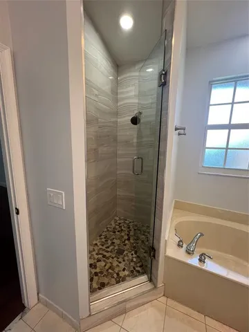 a bathroom with a shower and a bath tub