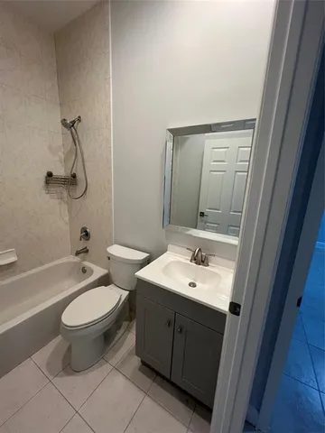 a bathroom with a granite countertop toilet a sink and a mirror