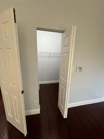an empty room with wooden floor and entrance